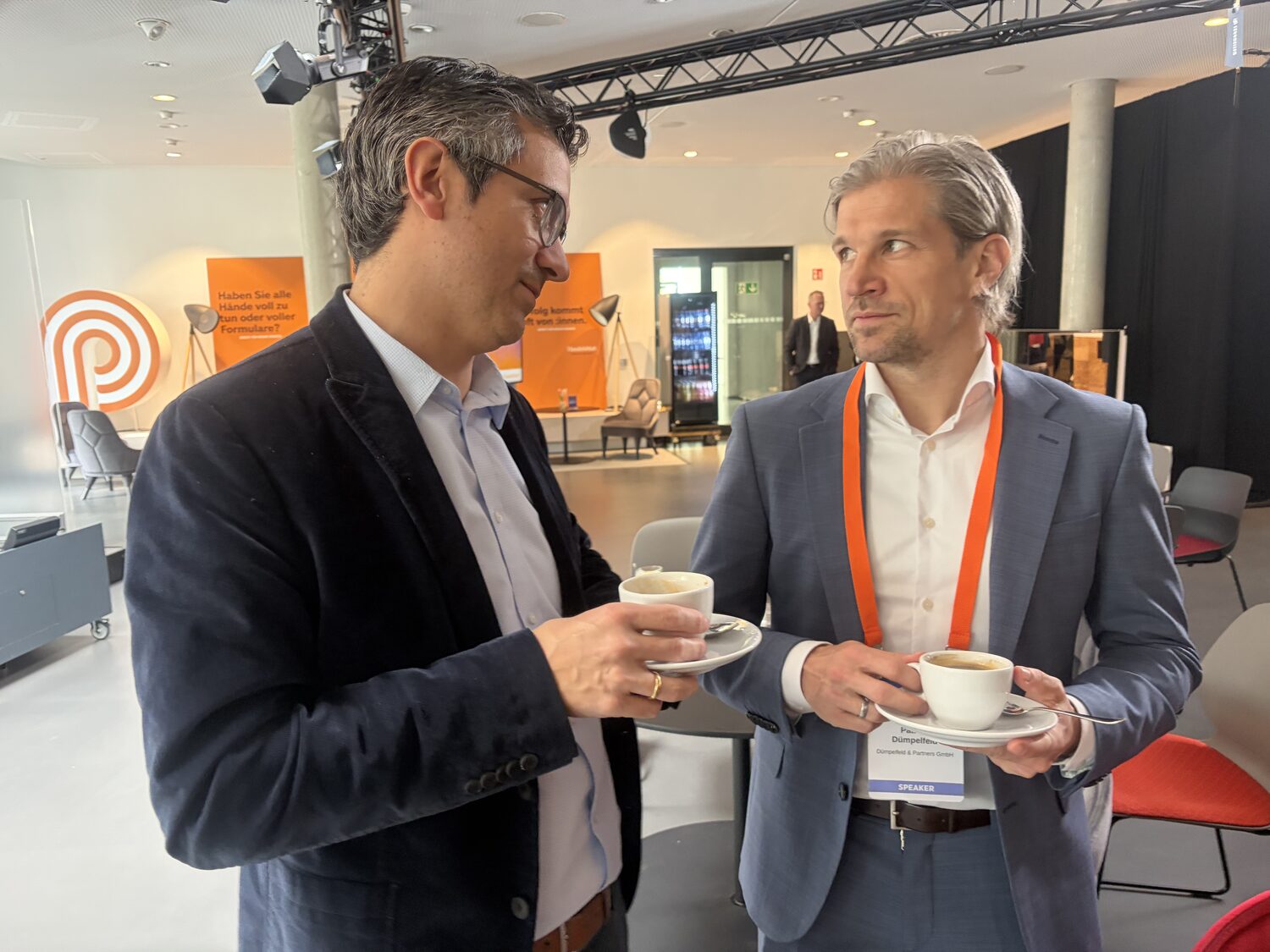 Austausch und Networking beim Handelsblatt CPO-Summit vor dem Dümpelfeld-Partners-Backdrop